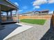 Landscaped backyard with a covered patio, grassy area, and gravel beds, perfect for outdoor entertaining at 656 N Bersshine St, Watkins, CO 80137