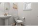 Modern powder room featuring a pedestal sink with gold fixtures and natural light at 656 N Bersshine St, Watkins, CO 80137