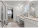 Bright bathroom with double sinks, modern vanity, step-in shower, and walk-in closet at 656 N Bersshine St, Watkins, CO 80137