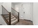 Bright foyer with wood-look floors, stairs with wood and iron railing, and a white front door at 656 N Bersshine St, Watkins, CO 80137