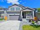 Attractive two-story home featuring gray siding, stone accents, landscaped front yard, and an attached garage at 656 N Bersshine St, Watkins, CO 80137