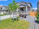 Inviting two-story home showcasing gray siding, stone accents, landscaped yard, and covered front porch at 656 N Bersshine St, Watkins, CO 80137