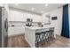 Contemporary kitchen featuring white cabinets, stainless steel appliances, an island with seating, and hardwood floors at 656 N Bersshine St, Watkins, CO 80137