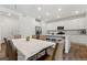 Open-concept kitchen and dining area with white cabinets, stainless steel appliances, and a center island at 656 N Bersshine St, Watkins, CO 80137