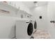 Convenient laundry room featuring a modern washer and dryer with built-in shelving at 656 N Bersshine St, Watkins, CO 80137