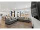 Spacious living room featuring hardwood floors, large windows, modern gray sofas, and an open floorplan at 656 N Bersshine St, Watkins, CO 80137