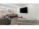 Bright living room with hardwood floors, large windows, comfortable sofas, and a mounted television at 656 N Bersshine St, Watkins, CO 80137