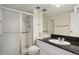 Bright bathroom with a glass-enclosed shower, modern fixtures, and a black countertop at 130 N Pearl St # 1103, Denver, CO 80203