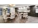 Dining and kitchen area featuring dark cabinetry, stainless appliances, and herringbone-patterned hardwood flooring at 130 N Pearl St # 1103, Denver, CO 80203