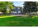 Spacious backyard with lush green grass, mature trees and a large home with a deck at 2089 Meadow Sweet Ln, Erie, CO 80516