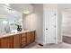 Primary bathroom features a dual sink vanity, granite counters, large mirror and closet at 2089 Meadow Sweet Ln, Erie, CO 80516