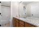 Bathroom with wood vanity, granite counters, and shower/tub combo with white tiled walls at 2089 Meadow Sweet Ln, Erie, CO 80516