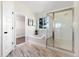 Bright bathroom with marble-look flooring, soaking tub, glass shower, and closet with shelving at 2089 Meadow Sweet Ln, Erie, CO 80516