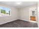 Carpeted bedroom with large window and view of the en suite bathroom at 2089 Meadow Sweet Ln, Erie, CO 80516