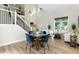 Bright, open living room with soaring ceilings, dining area, and modern staircase at 2089 Meadow Sweet Ln, Erie, CO 80516