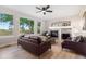 Comfortable living room featuring a fireplace, large windows, and a ceiling fan at 2089 Meadow Sweet Ln, Erie, CO 80516
