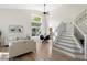Bright, open living room with soaring ceilings, dining area, and modern staircase at 2089 Meadow Sweet Ln, Erie, CO 80516