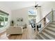 Bright, open living room with soaring ceilings, dining area, and modern staircase at 2089 Meadow Sweet Ln, Erie, CO 80516