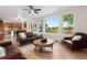 Comfortable living room featuring a fireplace, large windows, and a view into the kitchen at 2089 Meadow Sweet Ln, Erie, CO 80516