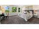 Bright main bedroom features large windows with lush views and neutral carpeting at 2089 Meadow Sweet Ln, Erie, CO 80516