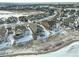 A high-angle aerial shot shows residential homes, snowy yards, and roads within a neighborhood at 15842 Willow St, Thornton, CO 80602