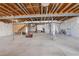 Spacious unfinished basement with exposed wooden ceiling beams, providing ample space for storage and customization at 15842 Willow St, Thornton, CO 80602