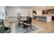 Open dining area with modern dark wood table and chairs, blue patterned rug, and barstool seating at kitchen counter at 15842 Willow St, Thornton, CO 80602