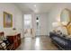 Bright entryway with wood floors, white walls, accent furniture, and access to other rooms at 15842 Willow St, Thornton, CO 80602