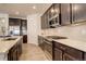 Modern kitchen featuring stainless steel appliances, light countertops, and dark wood cabinets at 15842 Willow St, Thornton, CO 80602