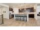 Modern kitchen with stainless steel appliances, an island with bar stools, and dark cabinets at 15842 Willow St, Thornton, CO 80602
