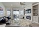 Inviting living room with a stone fireplace, built-in shelving, leather sofa, and sliding glass doors to a deck at 15842 Willow St, Thornton, CO 80602