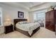 Cozy main bedroom features a tray ceiling, bay window with seat, upholstered headboard, and dark wood furniture at 15842 Willow St, Thornton, CO 80602
