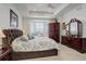 Elegant main bedroom with tray ceiling, bay window, upholstered headboard, and dark wood furniture at 15842 Willow St, Thornton, CO 80602