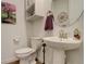 Modern powder room with pedestal sink, round mirror, and charming decorations at 15842 Willow St, Thornton, CO 80602