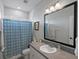 Bright bathroom featuring stylish vanity, framed mirror, and modern blue patterned shower curtain at 8354 Big Thompson St, Littleton, CO 80125