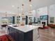 Open concept kitchen with an island, quartz countertop and flowing view to living room with fireplace at 8354 Big Thompson St, Littleton, CO 80125