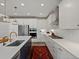 Modern kitchen with white cabinets, stainless steel appliances, island, and herringbone backsplash at 8354 Big Thompson St, Littleton, CO 80125