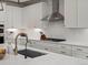Close-up of a bright modern kitchen featuring quartz countertops, white cabinets, and stainless steel appliances at 8354 Big Thompson St, Littleton, CO 80125