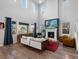 Open living room featuring soaring ceilings, a fireplace, hardwood floors, and modern furnishings at 8354 Big Thompson St, Littleton, CO 80125