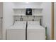 Functional laundry room with washer, dryer and overhead storage shelves for convenience and organization at 2525 S Dayton Way # 1514, Denver, CO 80231