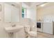 Bright bathroom featuring a sink, toilet, and a laundry area with a washer and dryer for added convenience at 5895 Biscay St # D, Denver, CO 80249