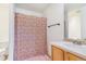 Bathroom with vanity sink, shower with decorative curtain, and toilet at 5895 Biscay St # D, Denver, CO 80249