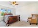 Cozy bedroom with a wooden sleigh bed, ceiling fan, and a patterned armchair at 5895 Biscay St # D, Denver, CO 80249