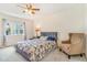 Bright bedroom features a patterned bedspread, ceiling fan, and a comfortable armchair at 5895 Biscay St # D, Denver, CO 80249
