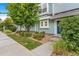 Inviting townhouse exterior with vibrant landscaping, a bright blue door, and a well-manicured lawn and walkway at 5895 Biscay St # D, Denver, CO 80249