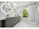 Primary bathroom with dual vanity, LED mirrors, and a window with natural light at 8701 E Briarwood Blvd, Centennial, CO 80112