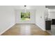 Minimalist dining room with hardwood floors, a modern light fixture, and a large window overlooking a serene yard at 8701 E Briarwood Blvd, Centennial, CO 80112