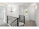 Bright upstairs hallway with a black iron railing and modern light fixture leads to bedrooms at 8701 E Briarwood Blvd, Centennial, CO 80112