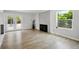 Spacious living room featuring hardwood floors, a cozy fireplace, and bright natural light from large windows at 8701 E Briarwood Blvd, Centennial, CO 80112