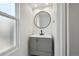 Stylish powder room with modern vanity, round mirror, and ample natural light at 8701 E Briarwood Blvd, Centennial, CO 80112